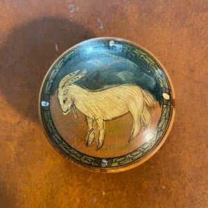 Round wooden box. Goat and bird images on lid. 2.5 in tall and 1 in wide.